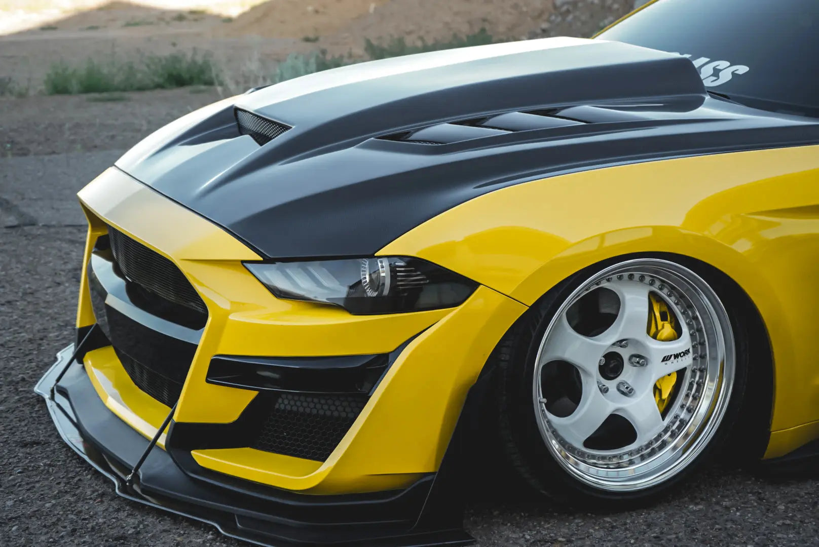 Yellow Ford Mustang fitted with a carbon fiber hood, front splitter, and aero body parts